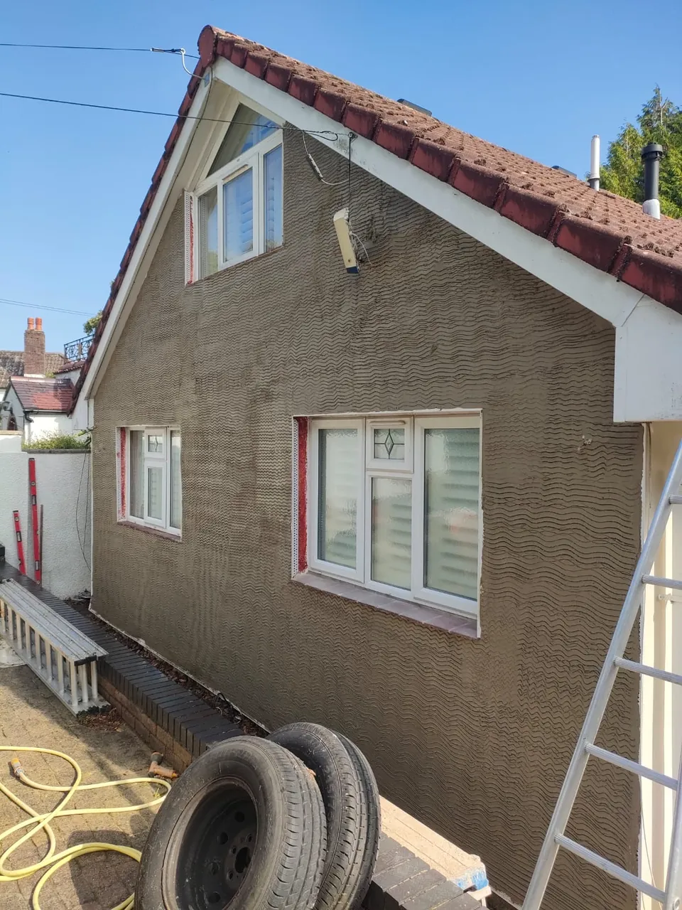 Gable end of a bungalow with the scratch coat of render applied, before the finish coat
