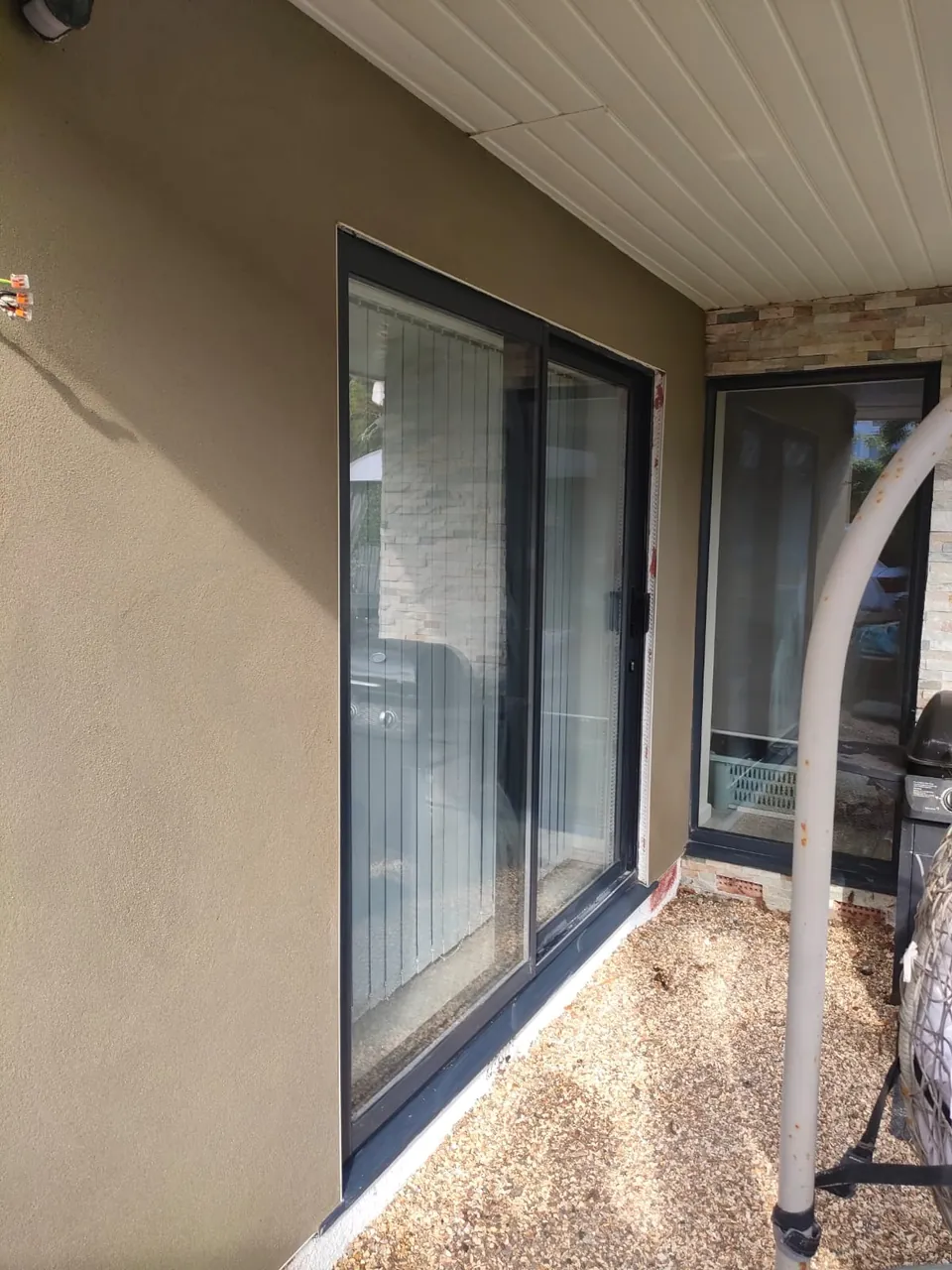 Finished render around dark framed sliding patio doors