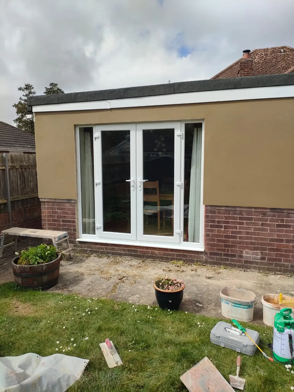 Finished smooth render around white French doors on the rear of a bungalow