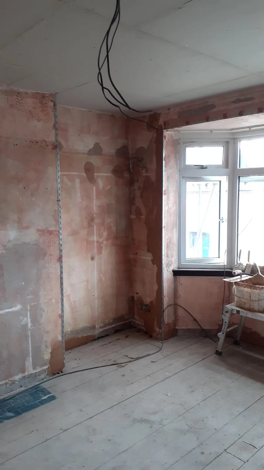 Bay window room with beads fitted, a bonding coat on the walls and patched areas ready for plastering