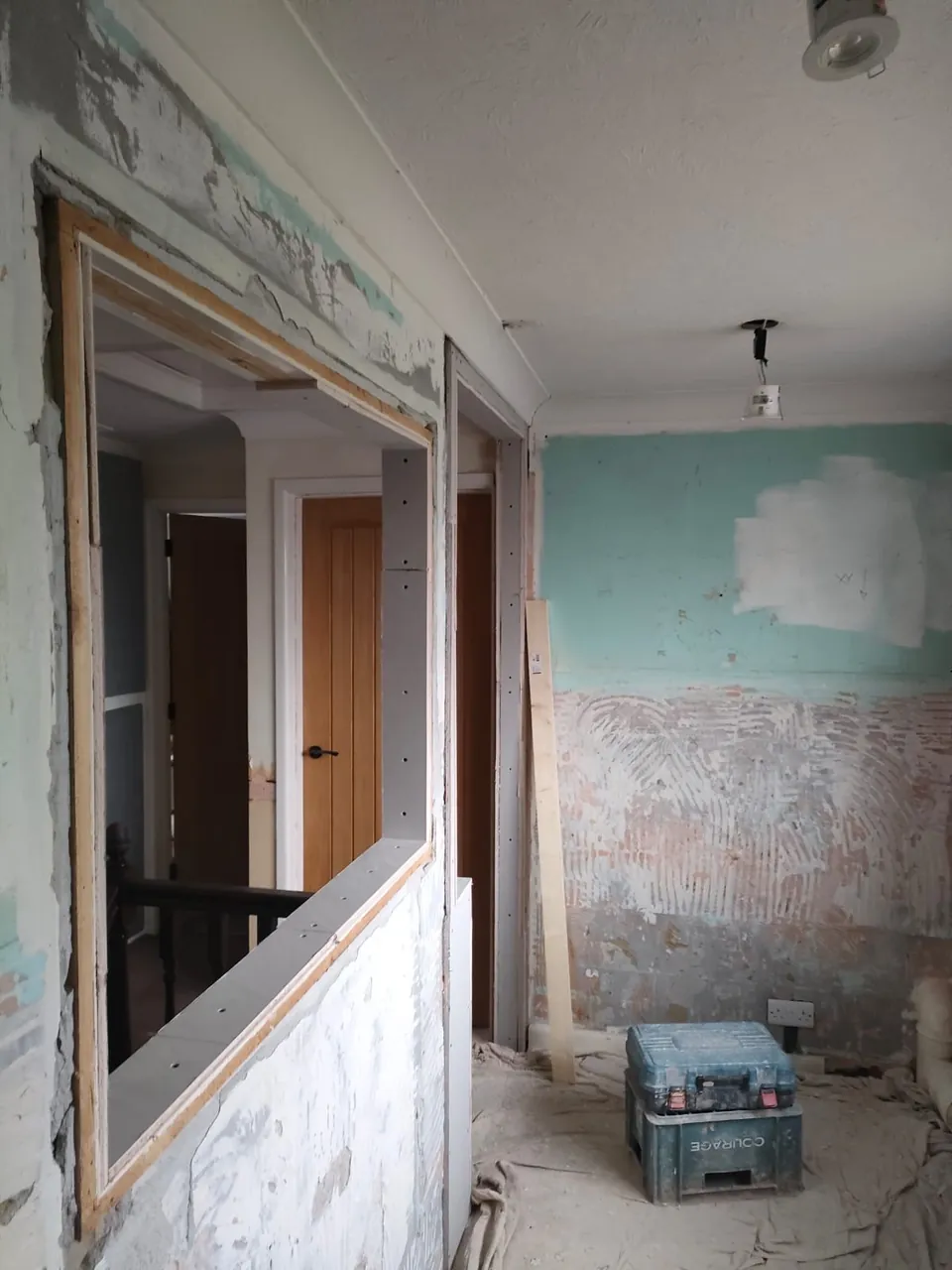 Landing wall stripped back with a timber framed opening to the stairs before plastering